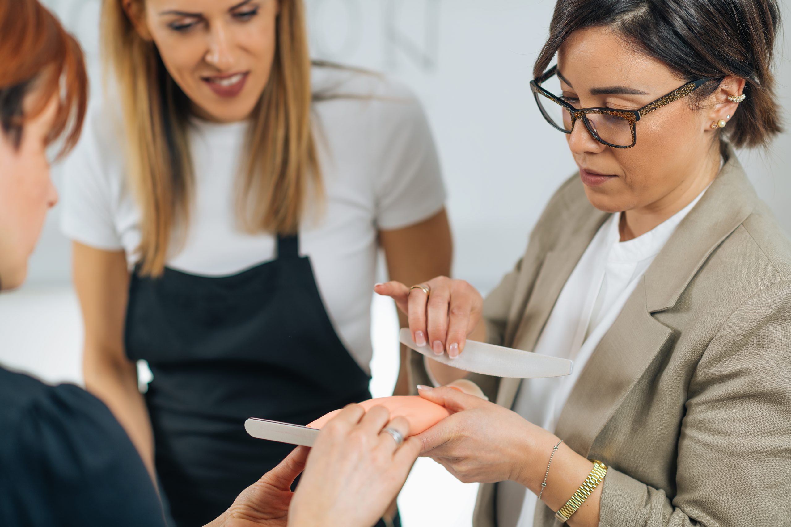An instructor providing hands-on guidance to a student practicing on an artificial hand during a beginner training program.