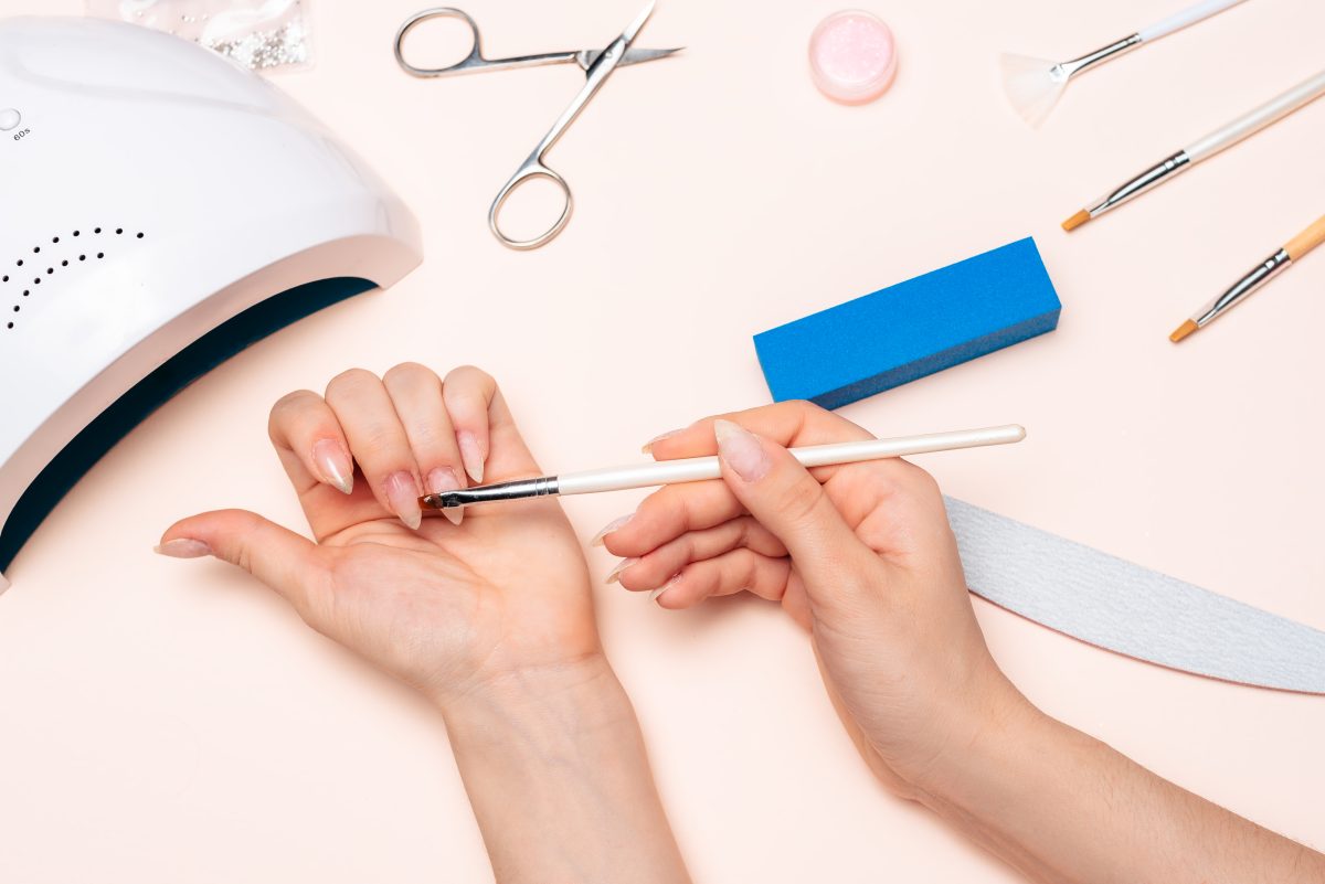 Manicure station showing the preparation stage for acrylic fills with nail files, buffers, and a UV lamp.